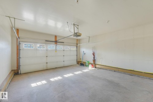 Garage with concrete flooring, white walls, and an automatic overhead door featuring window inserts - 1271 Ormsby Lane Nw, Edmonton, AB 
