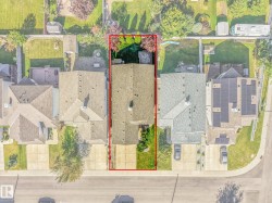 Sloped roof, paved driveway, mature landscaping, front yard, and backyard - 