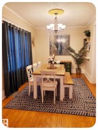 Hardwood flooring, crown molding, and a decorative ceiling medallion with a chandelier - 