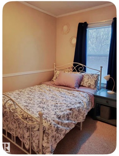 Window with blinds and dark curtains, light-colored walls with white trim, and a textured carpet - 10649 125 Street Nw, Edmonton, AB 