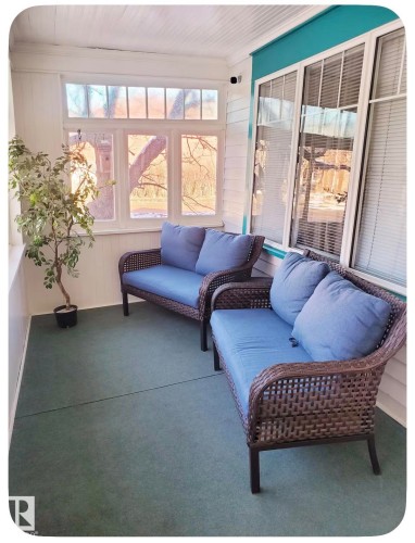 Enclosed porch featuring multiple windows, a white paneled ceiling, and green flooring - 10649 125 Street Nw, Edmonton, AB 