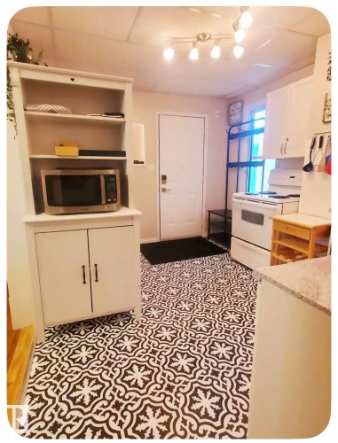 Patterned floor tiles, white cabinetry, light-colored walls, track lighting, and a solid entry door - 10649 125 Street Nw, Edmonton, AB 