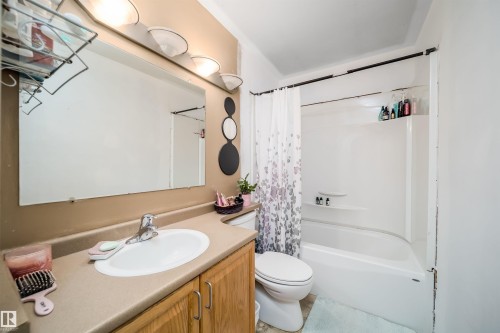 Bathroom featuring a single vanity with wood-finish cabinetry, an oval sink, and a laminate countertop - 4104 44 Street, Stony Plain, AB 