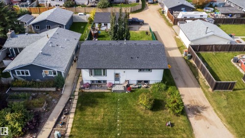 White exterior with dark roof, featuring a front lawn and paved walkway - 4104 44 Street, Stony Plain, AB 