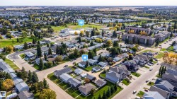 Aerial perspective showcasing a residential neighborhood with detached homes, apartment buildings, and green spaces - 