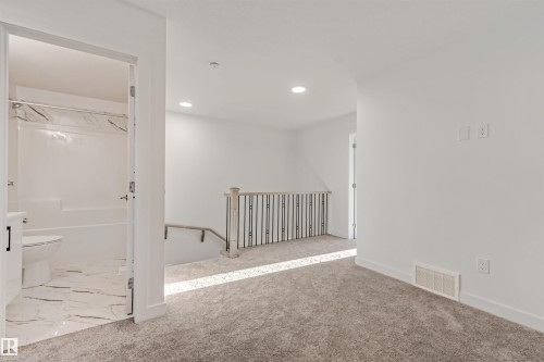 Plush carpeting, recessed lighting, and a modern stair railing with black spindles - 1515 211 Street Nw, Edmonton, AB 