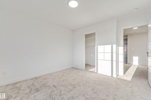 Neutral tone wall paint, plush carpet flooring, recessed ceiling lighting, built-in closet shelving - 1515 211 Street Nw, Edmonton, AB 