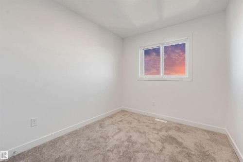 Neutral wall paint, carpet flooring, window with white trim, and white baseboards - 1515 211 Street Nw, Edmonton, AB 