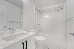 White vanity with integrated rectangular sink, chrome faucet, and black hardware - 