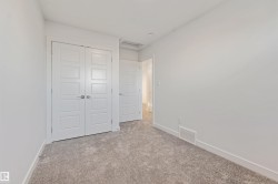 Neutral wall paint, plush carpeting, white trim, and a contemporary four-panel door - 