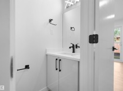Vanity with a white countertop and integrated sink, matte black faucet, and white cabinetry - 