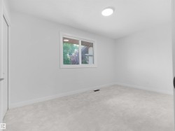 White interior paint, light-toned carpeting, white trim, and a window with white casing - 