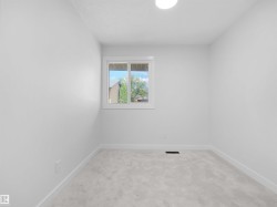 Light-colored wall-to-wall carpeting, white walls, and a window with white trim - 