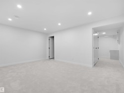 Recessed ceiling lighting illuminates the light-colored carpeting - 