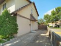 Exterior featuring vertical siding and stucco finishes, an asphalt driveway, and a wood privacy fence - 126 Woodstock Nw, Edmonton, AB 