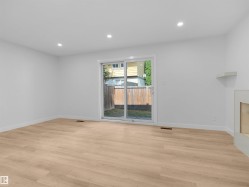 Wood-finish flooring, recessed ceiling lighting, and a sliding glass door - 