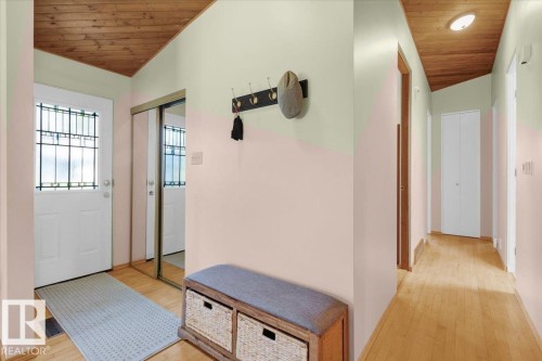 Entryway featuring a decorative glass pane door, wood-finish flooring, and a mirrored closet - 15012 77 Avenue Nw, Edmonton, AB 
