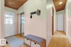 Entryway featuring a decorative glass pane door, wood-finish flooring, and a mirrored closet - 