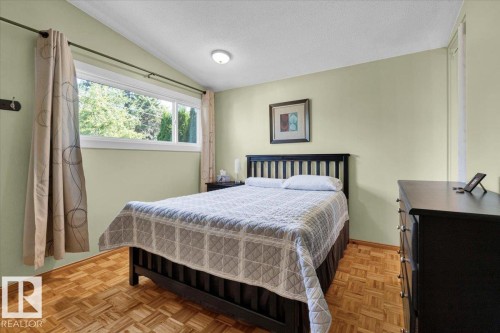 Vaulted ceiling, recessed ceiling light, large window, basket weave wood flooring, painted walls - 15012 77 Avenue Nw, Edmonton, AB 