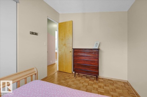 Parquet wood flooring, a light-toned wall finish, and a natural wood door - 15012 77 Avenue Nw, Edmonton, AB 