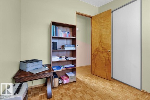 Parquet wood-finish flooring, light-toned wall finishes, wood-paneled door, and built-in shelving - 15012 77 Avenue Nw, Edmonton, AB 