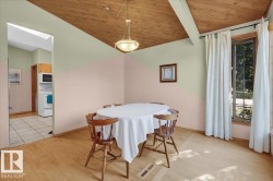 Wood-finish flooring, wood plank ceiling, exposed ceiling beams, recessed lighting, and a large window - 