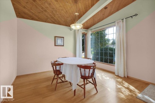 Angled wood-paneled ceiling with exposed beams, wood-finish flooring, and large picture windows - 15012 77 Avenue Nw, Edmonton, AB 