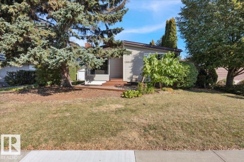 Siding exterior with a prominent front window and a contrasting wood-finish deck - 15012 77 Avenue Nw, Edmonton, AB 