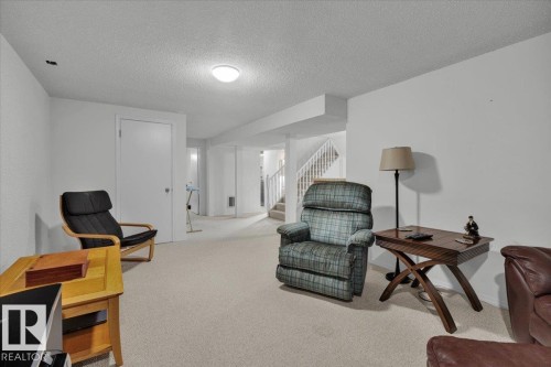 Carpeted flooring, white walls, white ceiling, white interior doors, and a staircase with white railings - 15012 77 Avenue Nw, Edmonton, AB 