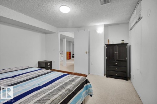 White textured ceiling, light neutral carpeting, and a built-in wall sconce - 15012 77 Avenue Nw, Edmonton, AB 