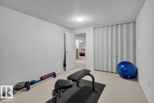 Neutral-toned wall finishes, carpeted flooring, overhead lighting, and accordion-style closet doors - 15012 77 Avenue Nw, Edmonton, AB 