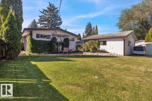 Expansive lawn with mature landscaping and a paved patio area - 15012 77 Avenue Nw, Edmonton, AB 