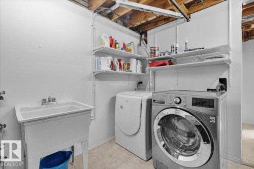 Utility space featuring a laundry sink, durable flooring, and built-in wall shelving - 15012 77 Avenue Nw, Edmonton, AB 