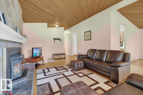 Vaulted wood-paneled ceiling, stone-clad fireplace with mantel, and wood-finish flooring - 15012 77 Avenue Nw, Edmonton, AB 