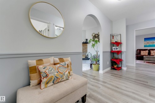 Light wood-finish flooring, two-tone wall paneling, and an arched doorway - #37 23020 Township Road 522 Rd, Rural Strathcona County, AB 