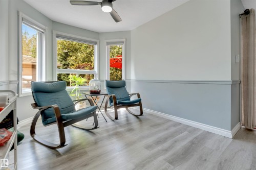 Bay window with multiple windows, wood-finish flooring, two-tone painted walls, and a ceiling fan with integrated lighting - #37 23020 Township Road 522 Rd, Rural Strathcona County, AB 