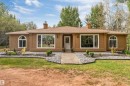 Exterior featuring a light brown stucco finish, white-framed windows, and a brown shingle roof - #37 23020 Township Road 522 Rd, Rural Strathcona County, AB 
