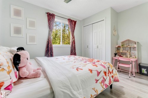 Window with natural light, bi-fold closet doors, light-toned walls, and wood-finish flooring - #37 23020 Township Road 522 Rd, Rural Strathcona County, AB 