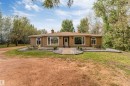 Single-story residence featuring a stucco exterior, multiple large windows, and a prominent front entry with an arched transom - #37 23020 Township Road 522 Rd, Rural Strathcona County, AB 