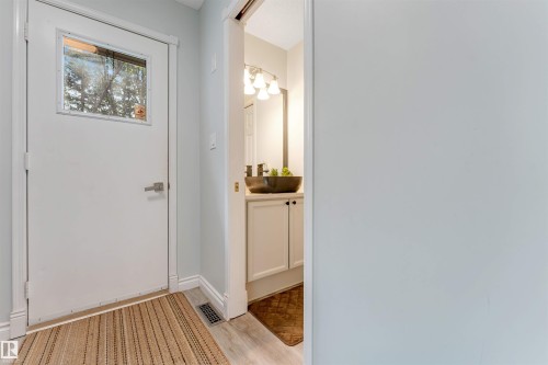 Entry door with upper window pane, light-toned wall finish, and wood-finish flooring - #37 23020 Township Road 522 Rd, Rural Strathcona County, AB 