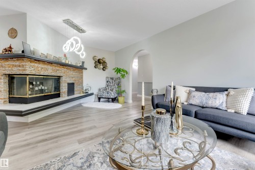 Vaulted ceilings, a stone-clad fireplace, wood-finish flooring, and an arched doorway - #37 23020 Township Road 522 Rd, Rural Strathcona County, AB 