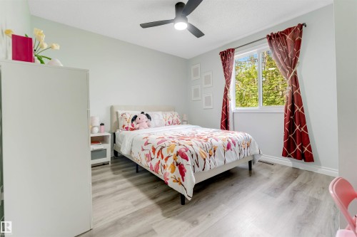Light wood-finish flooring, a ceiling fan with integrated lighting, and a window with white trim - #37 23020 Township Road 522 Rd, Rural Strathcona County, AB 