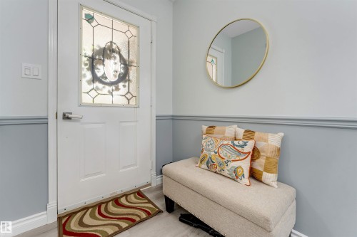 Entryway featuring a white door with decorative glass, two-tone painted walls with chair rail molding, and light-toned flooring - #37 23020 Township Road 522 Rd, Rural Strathcona County, AB 