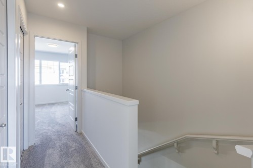 Recessed ceiling lighting, light gray wall paint, white trim, gray carpet, and white paneled doors - 3611 Triomphe Boulevard, Beaumont, AB 
