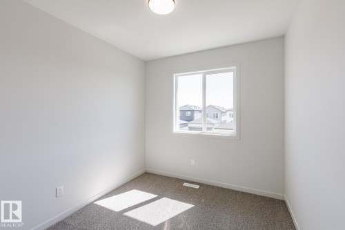 Neutral wall tones with a window, wall outlet, and ceiling light fixture - 3611 Triomphe Boulevard, Beaumont, AB 