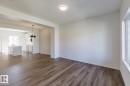 Open-concept layout with wood-finish flooring, recessed lighting, and a modern kitchen island with an undermount sink - 3611 Triomphe Boulevard, Beaumont, AB 