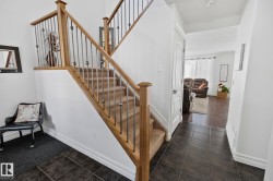 Carpeted staircase with wood-finish handrails and metal balusters - 