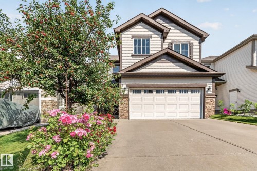 Two-story exterior with horizontal siding, stone accents, and a dual-pane garage door - 1115 61 Street Sw, Edmonton, AB 