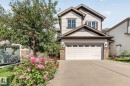 Two-story exterior with horizontal siding, stone accents, and a dual-pane garage door - 1115 61 Street Sw, Edmonton, AB 