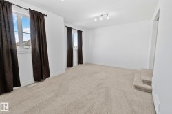 Neutral carpet flooring, white walls, two windows, and track lighting - 